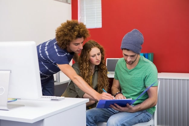 College students participating in a co-op or internship program in a tech company, working on computers and collaborating on a project. The image shows the practical application of their studies and the direct relevance to the industry.