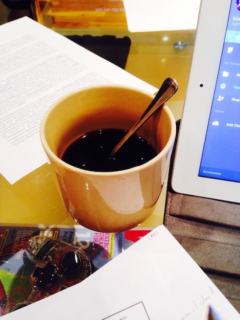 A close-up of a tax form with a pen highlighting a specific line item, along with a pair of glasses and a cup of coffee, illustrating the attention to detail required in tax preparation.