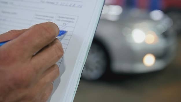 A close-up shot of a car manufacturer receiving a tax incentive document, highlighting the financial benefits of the program.