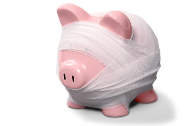 A piggy bank with a bandage, symbolizing the importance of a financial safety net and emergency savings.