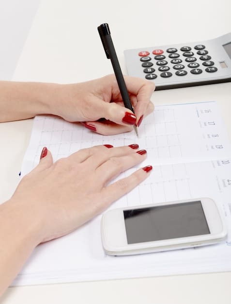 Close-up of hands using a calculator alongside various tax forms and a pen, emphasizing precision and calculations in tax preparation and planning.