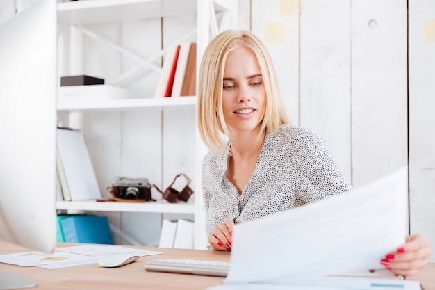 A young woman receiving a life insurance policy document from an insurance agent in a bright, modern office setting. The woman is smiling and looks relieved.